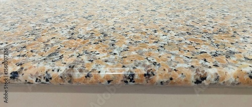 Close up view of a polished granite countertop edge with speckled pattern