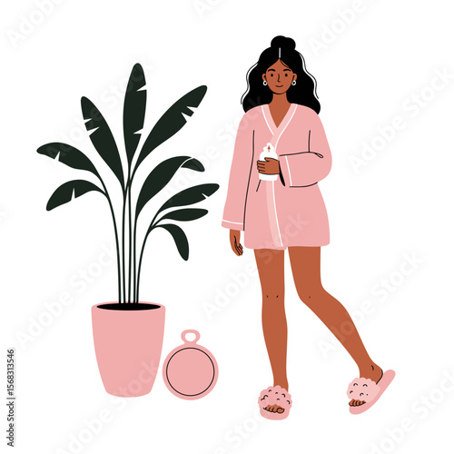 Young woman in pink robe holding a cup beside indoor plant  