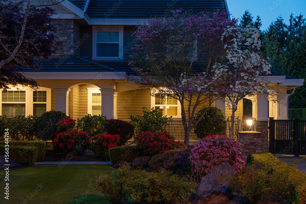 Fototapeta premium Entrance of luxury house with nice spring blossom landscape at night in Vancouver, Canada, North America. May 2025.