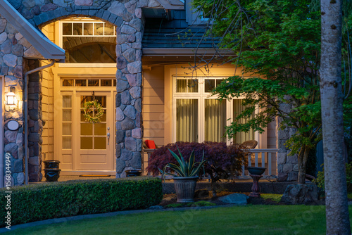 Entrance of luxury house with nice spring blossom landscape at night in Vancouver, Canada, North America. May 2025.