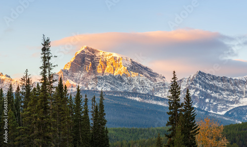 Majestic limestone mountain peak bathed in warm golden during sunset of Canadian Rocky Mountains around Banff Gondola in Banff National Park, Alberta, Canada