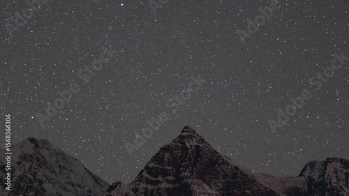 4K Zoom In Night lapse shot of stars moving in the sky above the snowy Himalayan mountain peak at Gondhla village in Lahaul and Spiti district, Himachal Pradesh, India. Stars move above the mountain.