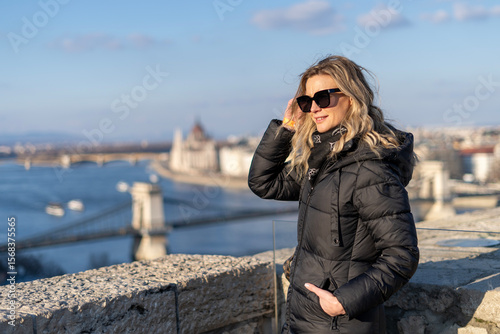 Photography Blonde woman posing in winter Budapest, with downtown Pest with the Chain Bridge