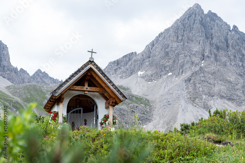 Photos Christian chapel in austrian alps with wooden roof in front of granite mountain