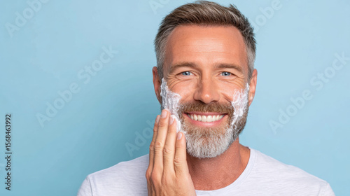 Man applying aftershave balm after shaving for skincare routine.