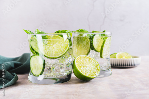Spa spritz with cucumber, lime and basil in glasses on the table