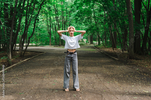 Teenage girl holding her head in horror on a path in the forest