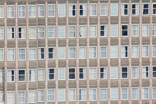 Foto Uniform facade of an apartment building featuring numerous windows, creating a r
