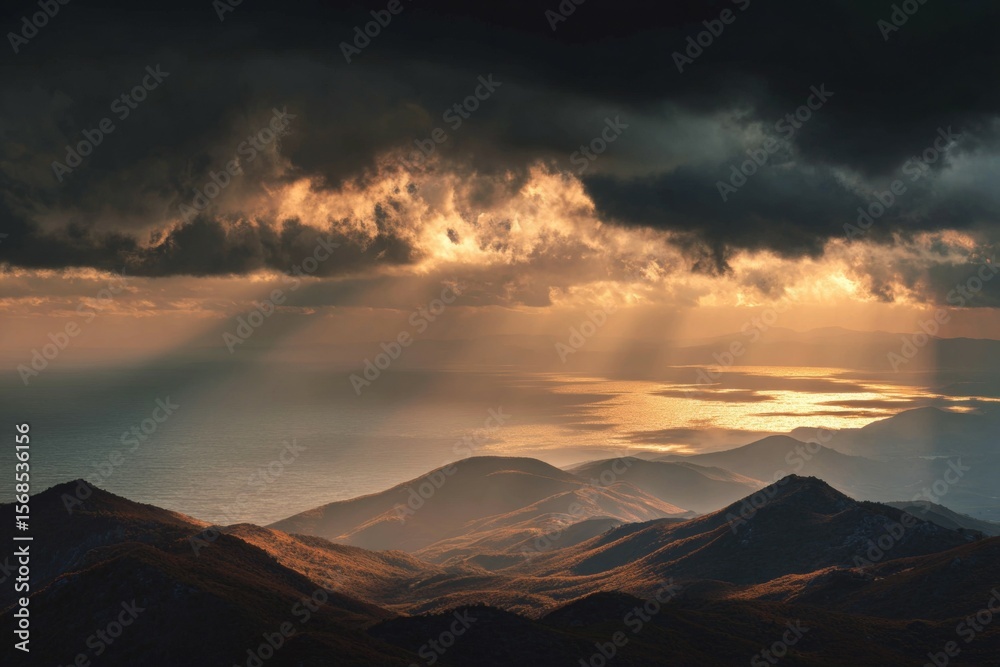 Dramatic sunset over mountain range with sun rays breaking through clouds Dramatic sunset over mountain range with sun rays breaking through clouds