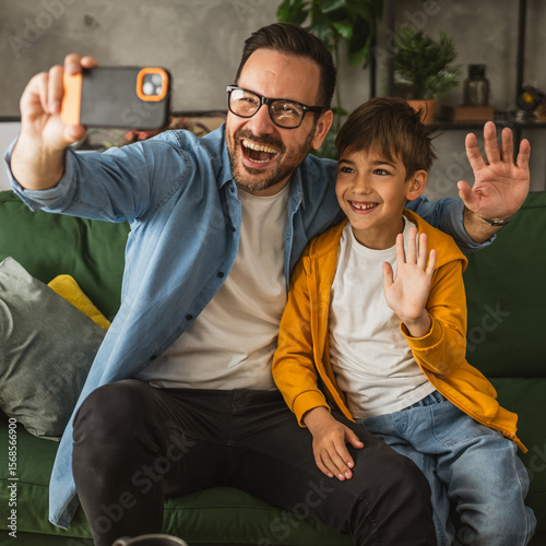 Father and son make a self portrait at living room