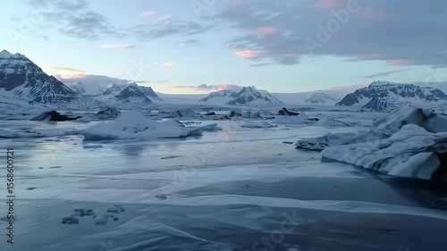 Arctic Landscape with Floating Ice Chunks on Glacier Lagoon Waters Under Blue and Pink Sky