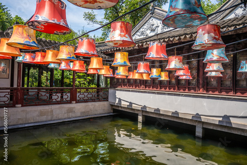 Ornate lanterns hang from a pavilion roof over a canal at Guyi Garden in Nanxiang, Shanghai, China. These lanterns reflect the artistry of traditional Chinese craftsmanship