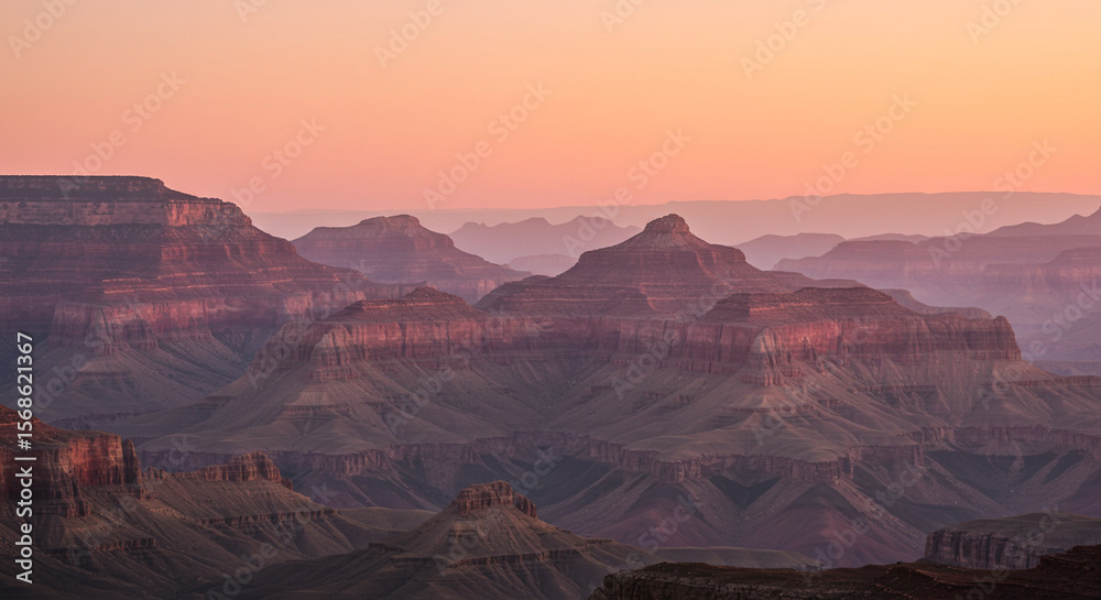 Naklejka premium Layered hills at sunset, warm light with pink haze in background