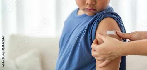 Fotografi Asian boy got vaccinated and receiving wound patch from medical doctor, showing