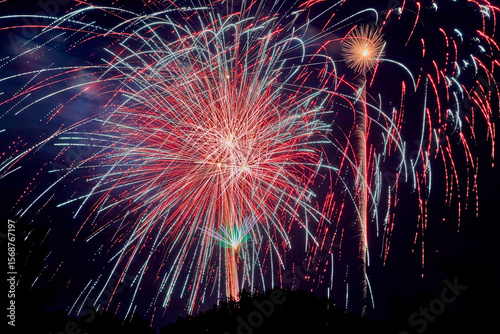 Wild fireworks filling the night sky with red, white, and blue bursts of light and color on the Fourth of July