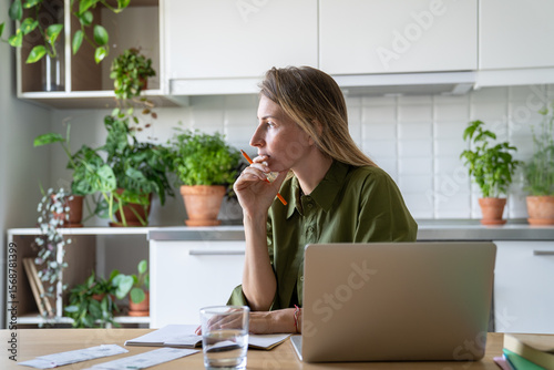 Billede på lærred Tired thoughtful puzzled woman reviewing housing charges using laptop