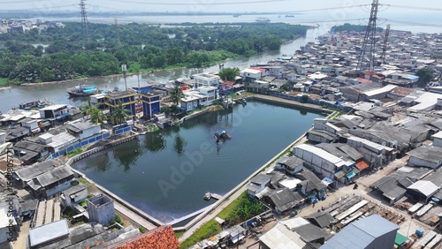 Fotografija View from above of an excavator dredging a lake on the riverbank in North Jakart