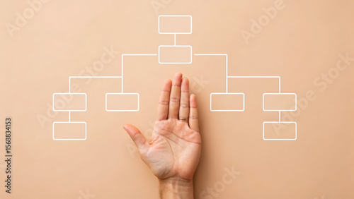 Hand placed near flowchart design on a neutral background.