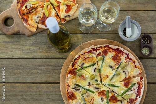 Pizza with white wine served on wooden table