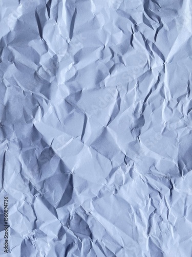 Wrinkled Paper Texture: Close-up shot of crumpled paper, highlighting texture, shadows, and folds, conveying concept of waste, process or creativity.