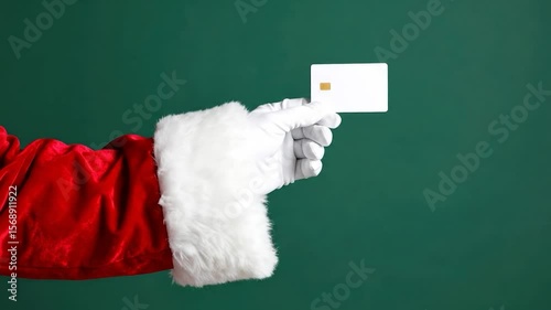 Wallpaper Mural Santa Claus hand holding a white credit card against a green backdrop Torontodigital.ca