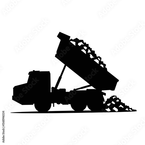 Silhouette of a dump truck unloading a load of materials.
