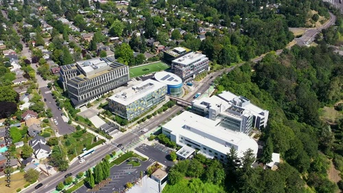4K aerial drone footage of modern office campus in Portland, Oregon, USA. Includes contemporary buildings, soccer field, green spaces, parking lots, and tree-lined residential neighborhood around.
