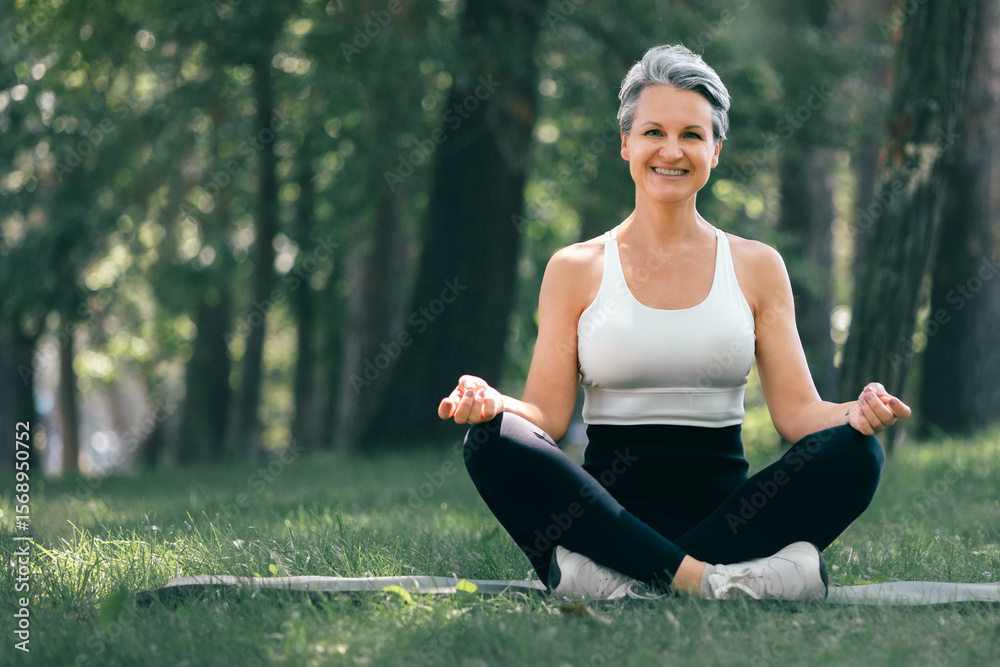 Happy Mature Woman Meditating Outdoors in Nature During Morning Yoga Session in the Park Happy Mature Woman Meditating Outdoors in Nature During Morning Yoga Session in the Park