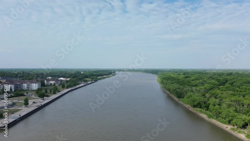 Wallpaper Mural Aerial drone flying over a wide river separating an urban area from a dense green forest. Nature vs civilization. Torontodigital.ca