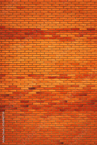 Vertical shot of orange clay brick wall pattern on a residential building facade