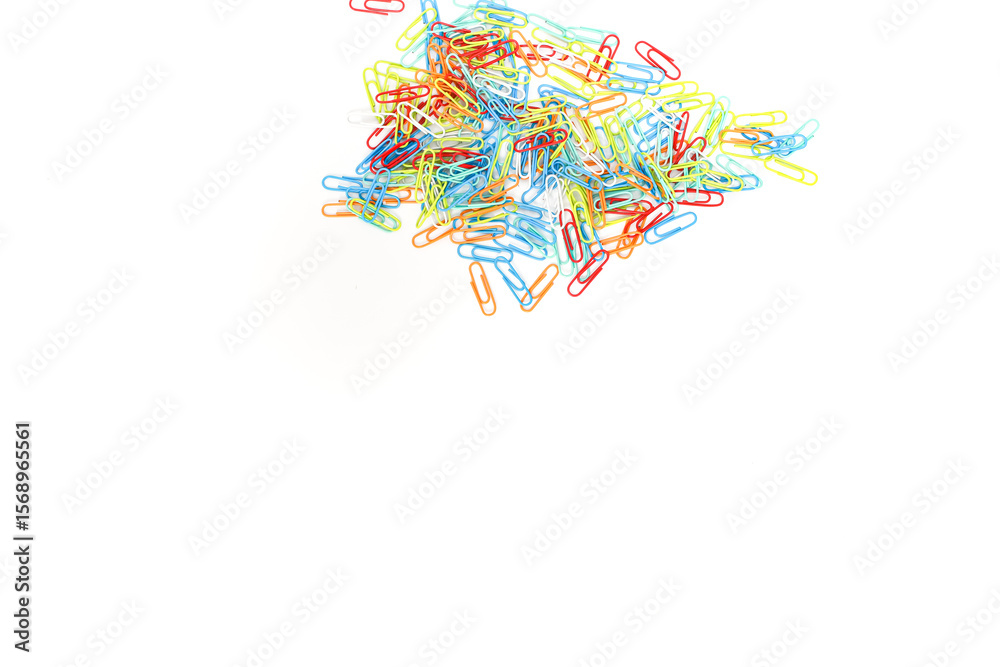 Fototapeta premium A vibrant cluster of colorful paper clips scattered on a clean, white background, creating a visually appealing stationery scene