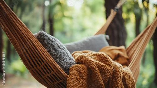 Brown hammock with blanket and pillow gently swinging