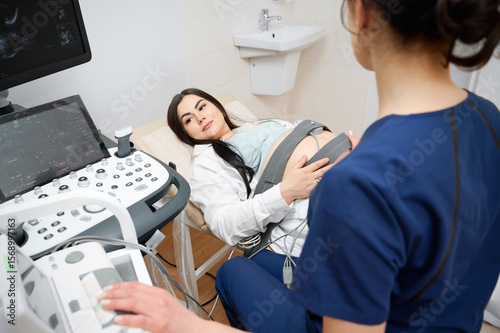 Behang Pregnant woman undergoing cardiotocography procedure