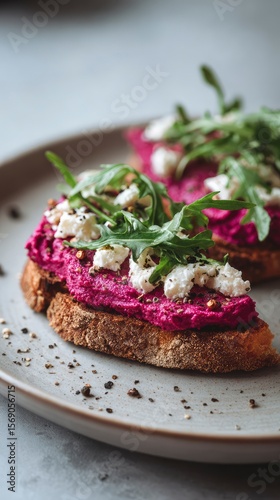 Wallpaper Mural Close-up of elegant open-faced toast with beetroot hummus, feta crumbles, arugula and cracked pepper Torontodigital.ca