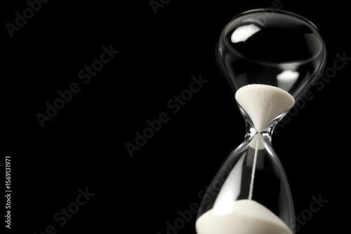 Simple hourglass. Black backdrop, copy space.