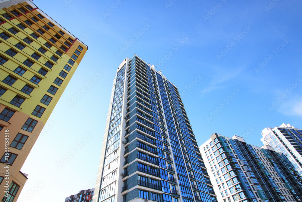 Fototapeta premium Gazing upward at an impressive tall building against a blue sky