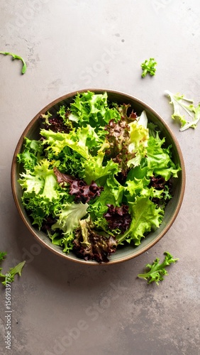 Fresh leafy salad mix in a rustic bowl on a neutral surface ideal for healthy meals