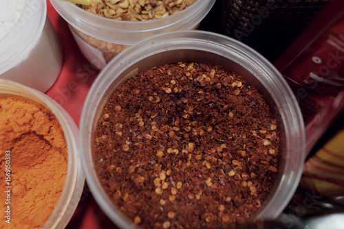 Fototapeta Naklejka Na Ścianę i Meble -  Crushed dried chili flakes in a clear container