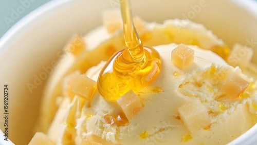 Delicious vanilla ice cream with honey drizzle and candied fruit pieces in a white bowl