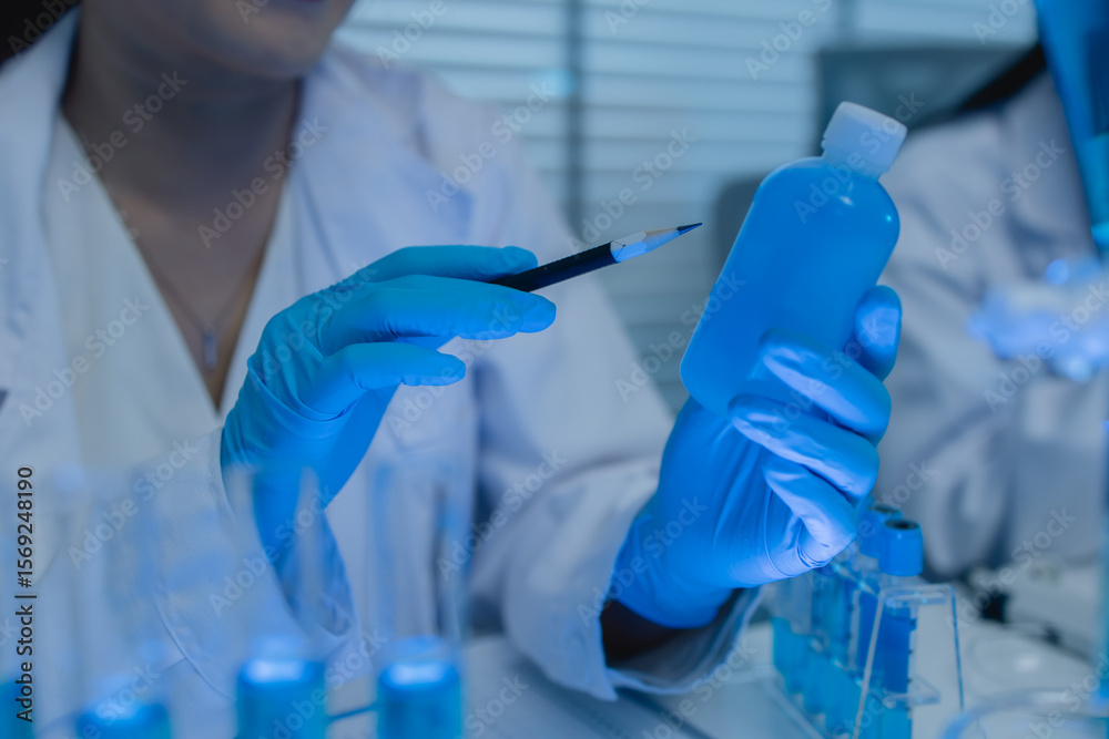 Fototapeta premium a female chemist is testing various liquid compounds in a lab, a scientist is doing research on the development, she wears a lab coat when she works in laboratory, test tube, scientific equipment
