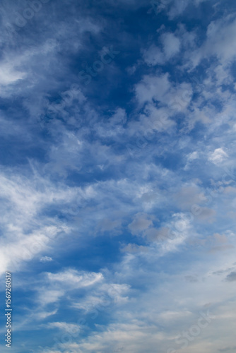 Cumulus and cirrus clouds on blue sky.