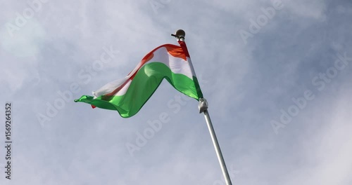 The flag of Niger, fluttering against the blue sky, is the national symbol of Niger. The video is presented in 4K format. The Niger flag is captured in close-up. Great for news.