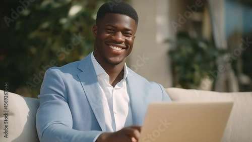 Young Black businessman working on laptop in modern coworking space