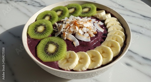 An acai bowl with kiwi, banana, and coconut flakes.