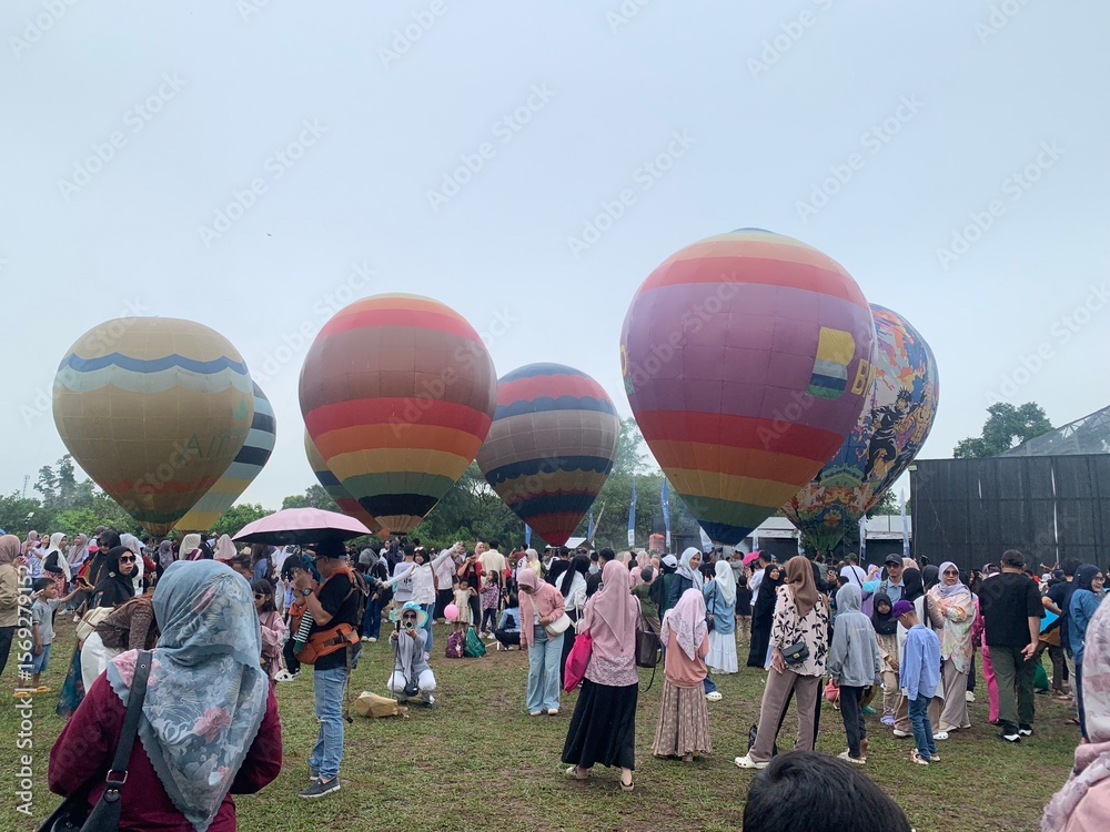 Obraz premium Colorful hot air balloons festival display distinct horizontal stripes are being inflated on the cloudy sky provide backdrop. 