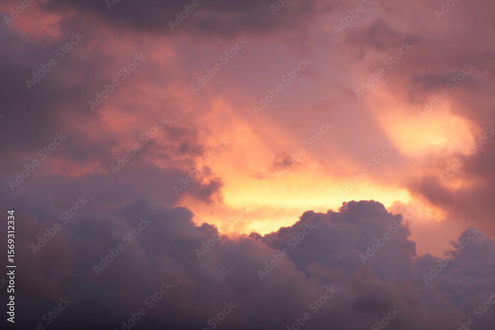 Fototapeta premium Toma de lejos de unas bellas nubes de color naranja o rojo en un cielo de color azul durante el atardecer