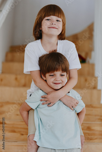 Obraz na plátne Two joyful boys playing together indoors, showcasing their playful spirits and brotherly bond in a charming home environment with natural light