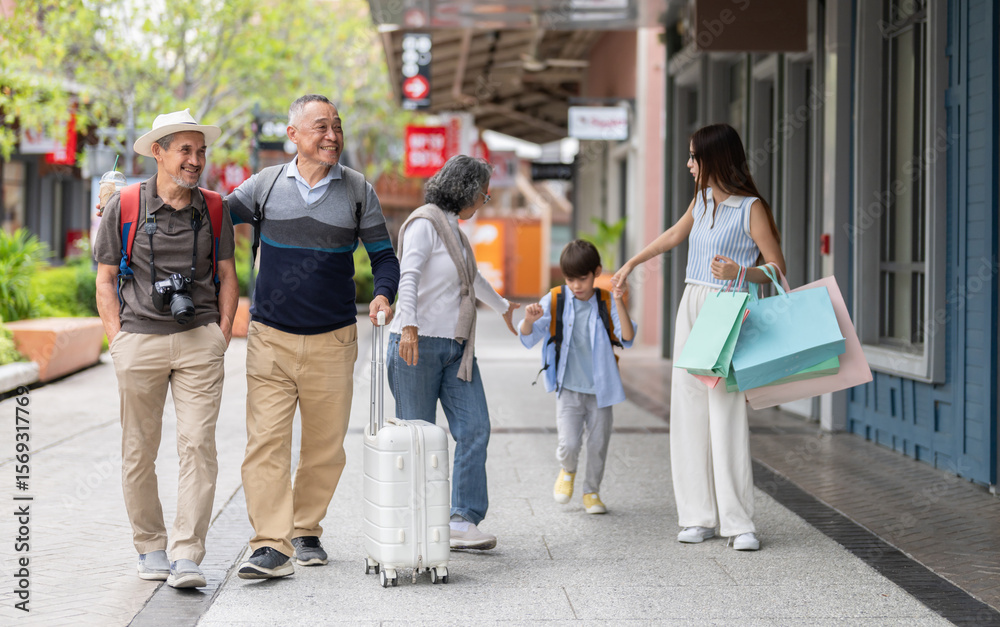 Fototapeta premium Multigenerational family walking travel and shopping in shopping street, happy grandparents parents and child enjoy vacation together with backpack retail with shopping bags showing family leisure