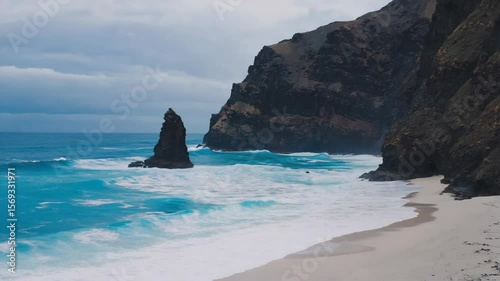 Majestic Coastal Cliff and Turquoise Waves on a Cloudy Day