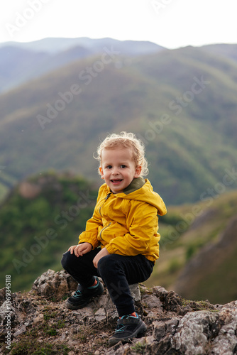 Wallpaper Mural Cute toddler in a yellow jacket enjoying and playing in the mountains at sunset. Little explorer learning through play.  Torontodigital.ca